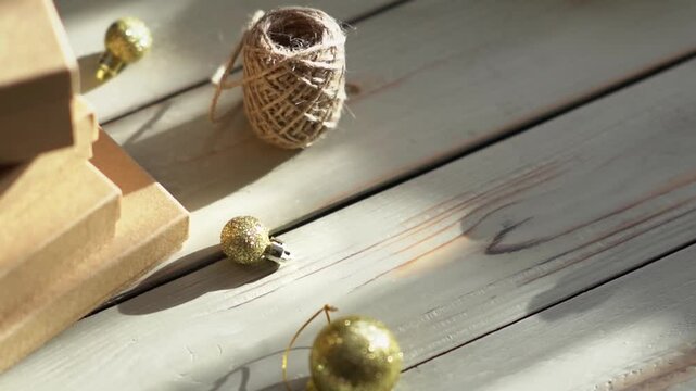 Holiday decor. Packing holiday gifts. Gift boxes, silver bow and Christmas gold balls against the backdrop of the Christmas tree and golden bokeh