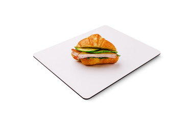 Delicious croissant sandwich with fresh ingredients on a clean surface
