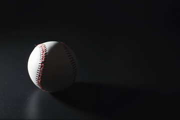 American traditional sports game. Baseball. Concept. Baseball ball and bats on a black table.