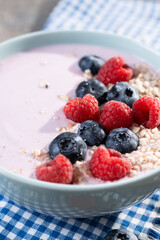 Healthy smoothie bowl with berries on wooden table. Close up
