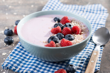 Healthy smoothie bowl with berries on wooden table