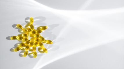 vitamin D or Fish oil yellow transparent capsules forming a sun shape on a white background, emphasizing themes of health, wellness, and nutrition