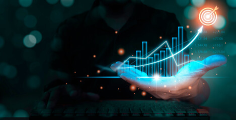 Man holding blue glowing economic growth charts for business finance and financial decisions, stock...