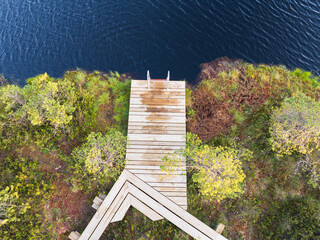Drone view of a wooden pier with a ladder in a calm bog lake, an ideal place for secluded summer...