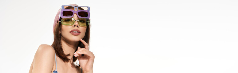 Stylish young woman showcasing vibrant fashion and playful attitude in trendy sunglasses