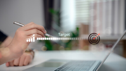 Hand pointing at digital progress bar with target icon on laptop. Concept of business goal achievement, marketing strategy, KPI progress, and success tracking in digital planning.
