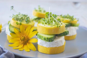 Cucumber and zucchini rolls with cream cheese and microgreens on a plate, healthy food, vegetarian food. 