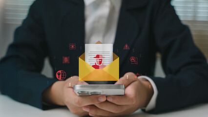 Phishing email alert icon above smartphone in businessman's hand. Cybersecurity warning concept,...