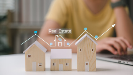 Miniature wooden houses with rising real estate trend graph. Concept of property investment,...