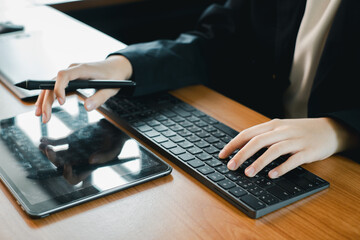 Hands using a tablet and keyboard, ideal for digital design, creativity, and modern office work...