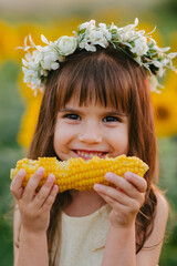 Happy little girl in sunflower field in summer