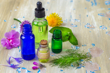 Essential oils and herbs on wooden surface