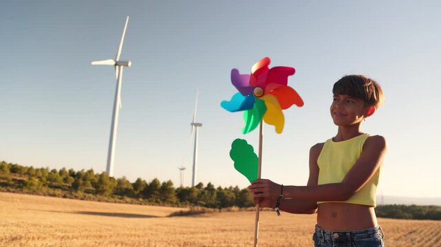 Young girl holding pinwheel in wheat field at sunset, slow motion montage