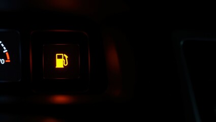 empty gas tank warning light. Fuel gauge warning light illuminating in dark car interior.   