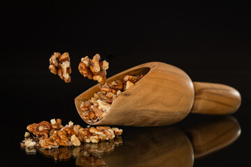 a handful of peeled walnuts in a wooden spatula
