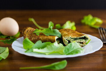 Homemade omelette roll with salad and green leaves