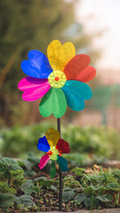 Two colorful pinwheels with heart-shaped petals are spinning in the gentle summer breeze, adding a...