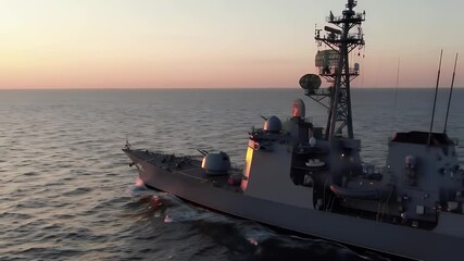 Warship Sailing the Open Sea at Sunset with Golden Light Casting Warm Glow with Towering Masts Against Colorful Sky