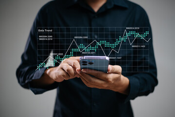 Hand using a stylus on tablet with digital trend graph overlay and laptop. Ideal for fintech,...