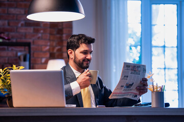 Executive reads business paper at desk, showing focus, awareness, and interest in financial updates