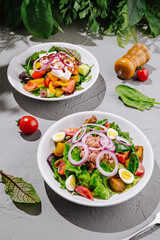 Colorful salad bowls featuring fresh vegetables and toppings on a gray table
