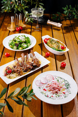 Exquisite dishes on a wooden table featuring salad and entrees