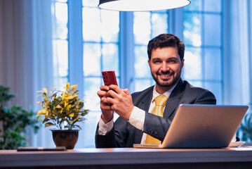 Corporate man typing on phone at work desk, representing modern business communication and focus