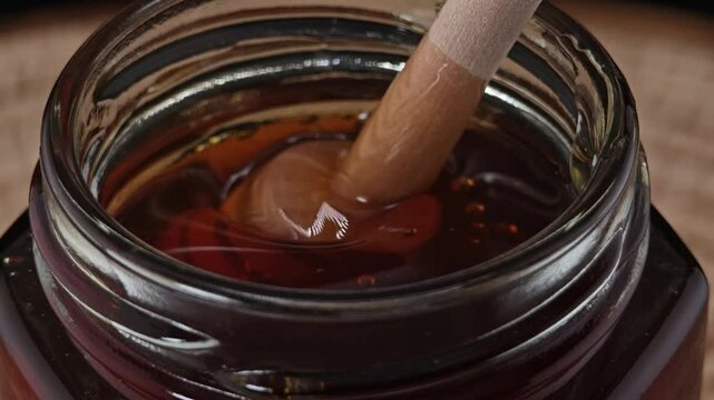 Honey wooden dipper on black background.

