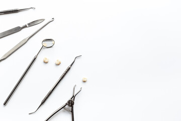 Many dental metal tools and teeth crows for implantation on white background. Professional Dentist desktop, top view