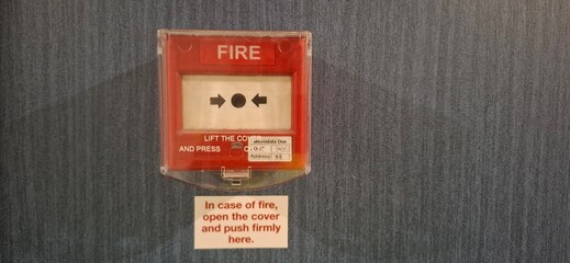Red Fire Alarm Unit Mounted on Blue Wall With Instruction for Emergency Use