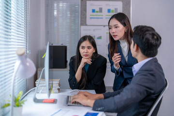 Three people in a meeting room, two women and a man