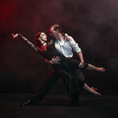 Graceful dancers execute a heartfelt Argentine tango against a misty and dim backdrop. Concept of deep feeling and cultural storytelling through the art of dance.