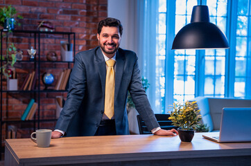 Indian businessman standing in style at desk, confident leader showing pride and authority