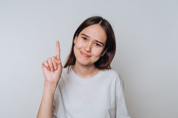 Woman showing a finger gesture to indicate a thoughtful idea while wearing a casual shirt in a...
