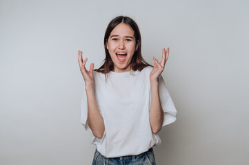 Excited young woman expressing joy and enthusiasm against a plain background in a casual setting