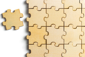 Wooden puzzle pieces and a completed jigsaw puzzle with white background. concept of comparison or...