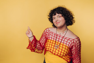 Young individual in vibrant attire poses against a bright yellow background showcasing confidence...