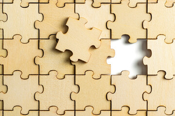 incomplete wooden jigsaw puzzle, with one final piece of jigsaw puzzle to complete the puzzle.on...