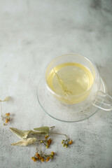 Brewed linden tea in teapot and cup on white background