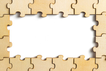 wooden jigsaw puzzle with missing pieces exposing empty white background for copy space.