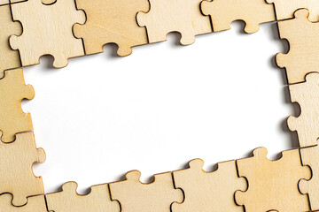 wooden jigsaw puzzle with missing pieces exposing empty white background for copy space.