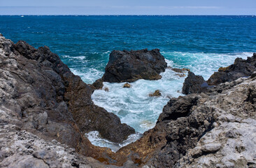 Waves hitting volcanic shoreline
