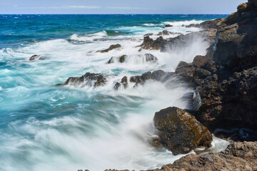 Waves hitting volcanic shoreline