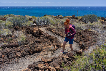 Fototapeta premium Photographer hiking through volcanic terrain