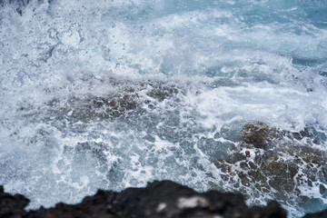 Waves hitting volcanic shoreline