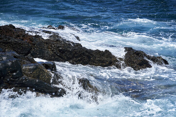 Waves hitting volcanic shoreline
