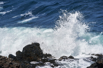 Waves hitting volcanic shoreline