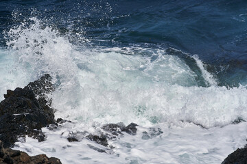 Waves hitting volcanic shoreline