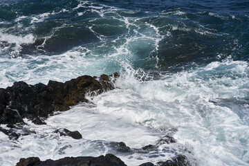 Waves hitting volcanic shoreline
