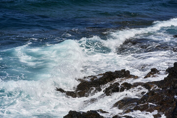 Waves hitting volcanic shoreline